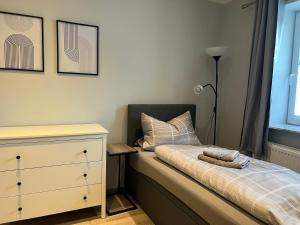 a small bedroom with a bed and a dresser at Ferienwohnungen Margot in Iserlohn