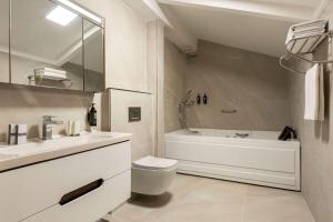 a bathroom with a tub and a toilet and a sink at Trademark By Wyndham Operla Airport Hotels Arnavutköy in Arnavutköy