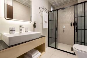 uma casa de banho branca com um lavatório e um chuveiro em Operla Airport Hotels, Trademark Collection by Wyndham em Arnavutköy