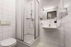 ein Bad mit einer Dusche, einem WC und einem Waschbecken in der Unterkunft Amedia Express Passau, Trademark Collection by Wyndham in Passau