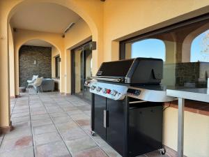 an outdoor kitchen with a grill on a patio at The Village in Cerdanyola del Valles