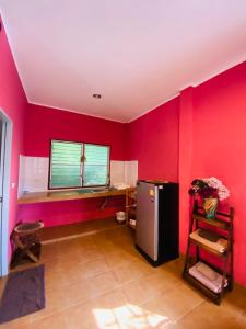 a red room with a refrigerator and a window at Mandala bungalow at Ya Nui beach in Rawai Beach