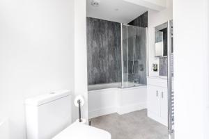 ブリストルにあるModern Spitfire with FREE PARKING by Prescott Apartmentsのシャワーと浴槽を備えた白いバスルーム +23枚の写真