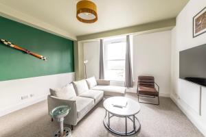 ブリストルにあるModern Spitfire with FREE PARKING by Prescott Apartmentsのソファとテーブルのあるリビングルーム