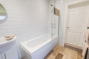 a white bathroom with a tub and a sink at Newly Renovated Family and Workspace Business Home in Runcorn, Cheshire ENTIRE HOUSE 