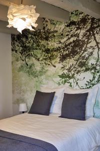 Schlafzimmer mit einem Bett mit Wandgemälde in der Unterkunft La Breizhidence in Combourg