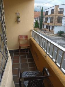 Un balcón con una silla, una mesa y una silla en coliving el jardin de envigado sede san marcos, en Envigado