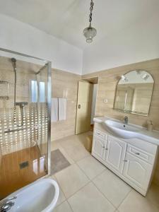 Un baño con bañera, lavabo y ducha. en Casa Ti Barbara, en Cachopo