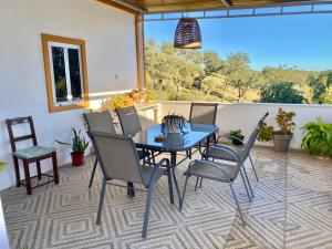 a patio with a table and chairs on a balcony at Casa Ti Barbara in Cachopo