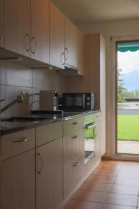 eine Küche mit einer Mikrowelle und einem Fenster in der Unterkunft Croisée A in Lens