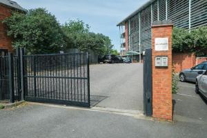 a gate in a parking lot next to a building at Peaceful Coventry Retreat - Free parking in Coventry