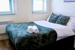 a bedroom with a bed with two towels on it at Peaceful Coventry Retreat - Free parking in Coventry