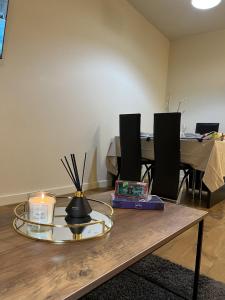 a room with a table with a candle and chairs at Peaceful Coventry Retreat - Free parking in Coventry