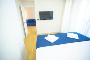 Habitación con 1 cama azul y 2 toallas blancas. en ORBI CITY BATUMI AMAZlNG APARTMENT en Batumi