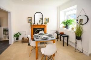 a dining room with a table and chairs and a mirror at Poet's Cottage Wonderful Cottage In The Welsh Valleys by STAE-Homes in Aberdare
