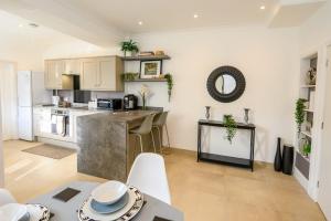 a kitchen and living room with a table and chairs at Poet's Cottage by StayStaycations in Aberdare