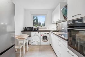 uma cozinha com uma máquina de lavar roupa e uma mesa em SC01 Großes Apartment bei FFM! em Mörfelden-Walldorf
