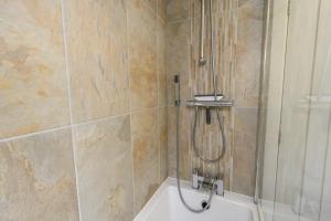 a bathroom with a shower and a bath tub at Poet's Cottage Wonderful Cottage In The Welsh Valleys by STAE-Homes in Aberdare +22 photos