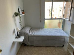 a small bedroom with a bed and a window at Bahia de Algeciras in Algeciras