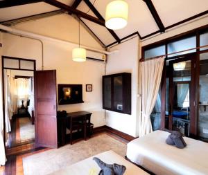 a room with two beds and a desk in it at Ban Chang Tong in Chiang Mai