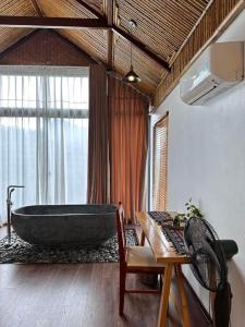 a bathroom with a large bath tub and a table at Thang Mây Village Resort in Ba Vì