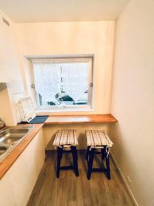 a kitchen with two stools in front of a window at Appartement spacieux Bastille - 5 pers in Paris