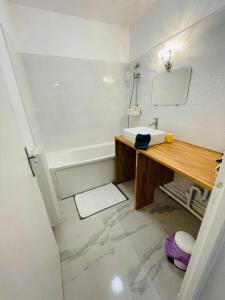 uma casa de banho com um lavatório e uma banheira em Appartement spacieux Bastille - 5 pers em Paris