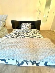 a bed with a comforter on it in a room at Appartement spacieux Bastille - 5 pers in Paris