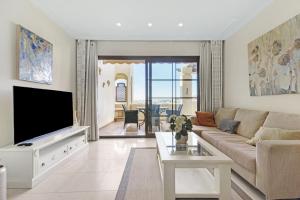 ein Wohnzimmer mit einem Sofa und einem TV in der Unterkunft Villa Gadea 11-6 in Altea
