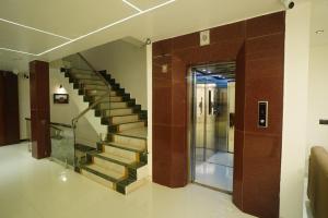 un escalier dans un bâtiment avec rampe en verre dans l'établissement HOTEL PRAHLAD INN, à Gwalior