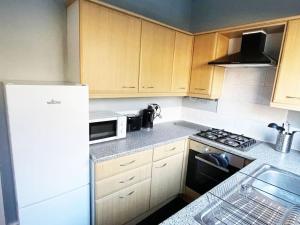 a kitchen with a white refrigerator and a microwave at Failsworth, Manchester in Manchester