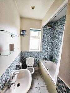 a bathroom with a sink and a toilet and a tub at Failsworth, Manchester in Manchester