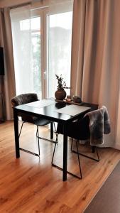 Luxury Apartment Vorstetten في Vörstetten: طاولة سوداء وكراسي في غرفة المعيشة