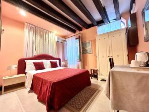 a bedroom with a red bed with a red blanket at Alloggi Serena in Venice