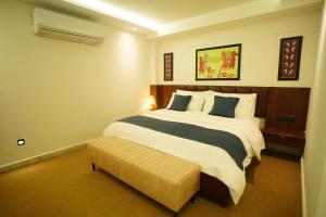 ein Schlafzimmer mit einem großen Bett und einer Bank in der Unterkunft HOTEL PRAHLAD INN in Gwalior