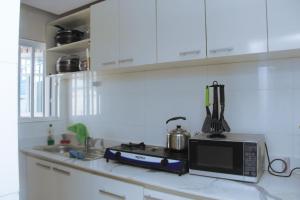a kitchen counter with a microwave and a sink at 3 bedroom apartment (fully furnished), Festac in Festac Town