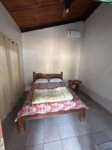 a bedroom with a bed with a quilt on it at Casadabiquinha in Pirenópolis
