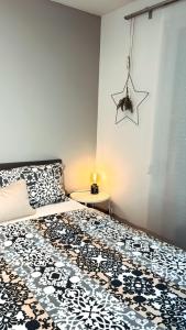 a bedroom with a bed with a black and white comforter at Luxury Apartment Vorstetten in Vörstetten