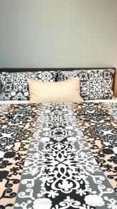 ein Bett mit einer schwarz-weißen Decke drauf in der Unterkunft Luxury Apartment Vorstetten in Vörstetten