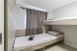 1 dormitorio con 2 literas y cortina en Apto lindo prox do mar em Balneário YVD1301, en Balneário Camboriú