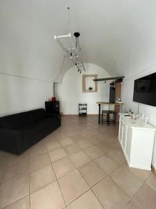 un soggiorno con divano nero e tavolo di 21mq Suite Homes Ostuni a Ostuni