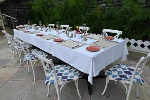 uma mesa longa com cadeiras e uma toalha de mesa branca em THE TRISHALA VILAS (A LUXURY BOUTIQUE HOTEL & SPA) em Ranakpur