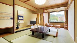 a living room with a table and a tv at Konya in Matsue