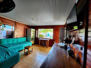 a living room with a green couch and a table at Pousada Suítes do Atlântico in Ilhéus