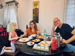 Un gruppo di persone seduti intorno a un tavolo che mangiano cibo di Reds Residency - Homestay a Cochin