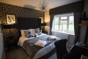 a bedroom with a bed with two towels on it at The Dog in Over Peover in Knutsford