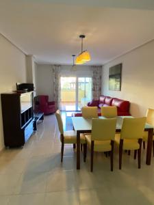 ein Wohnzimmer mit Tisch, Stühlen und Sofa in der Unterkunft Victor Villa Romana in Roquetas de Mar