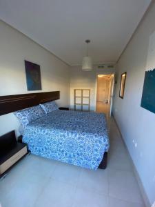 ein Schlafzimmer mit einem Bett mit einer blauen Bettdecke in der Unterkunft Victor Villa Romana in Roquetas de Mar + 30 Fotos