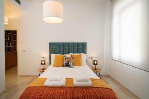 a bedroom with a large white bed with orange pillows at Apartamento Castilla 61 by SHS in Seville