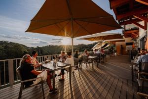 a group of people sitting at tables on a deck at Weingut Brenner am Rossberg in Glanz an der Weinstraße 